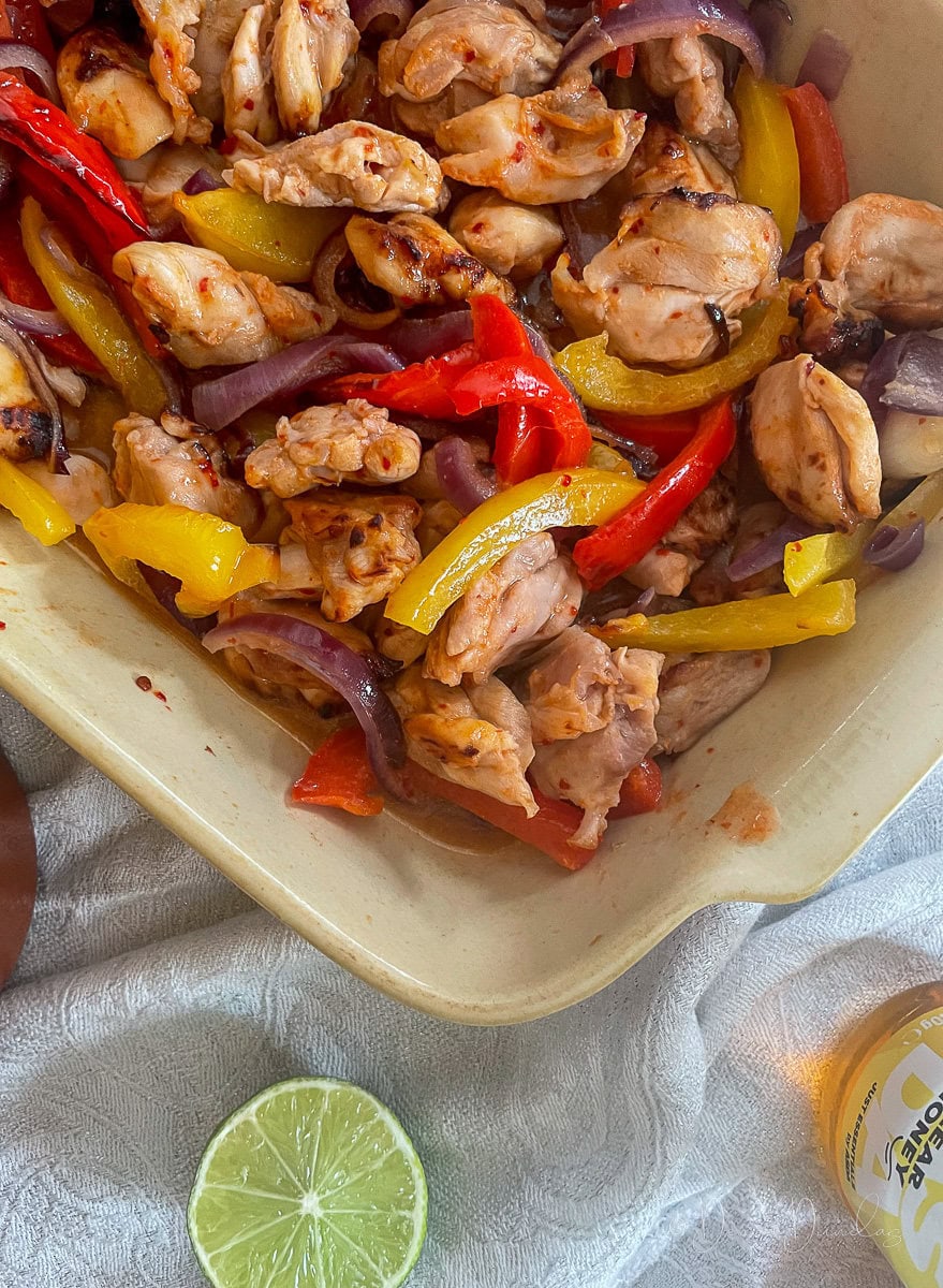close up of air fryer honey chilli chicken in serving bowl.