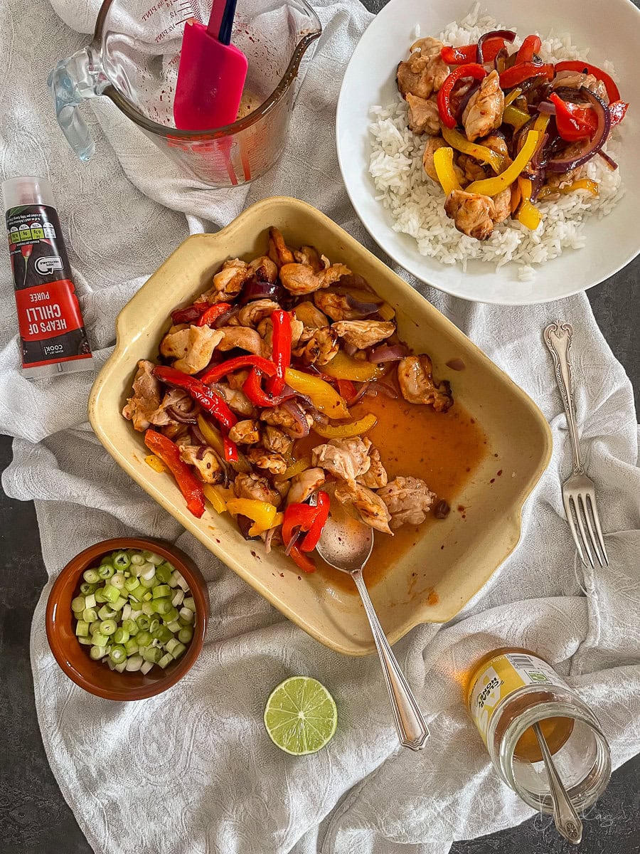 chicken, veg and honey chilli sauce in serving bowl. Served portion with rice to the side.