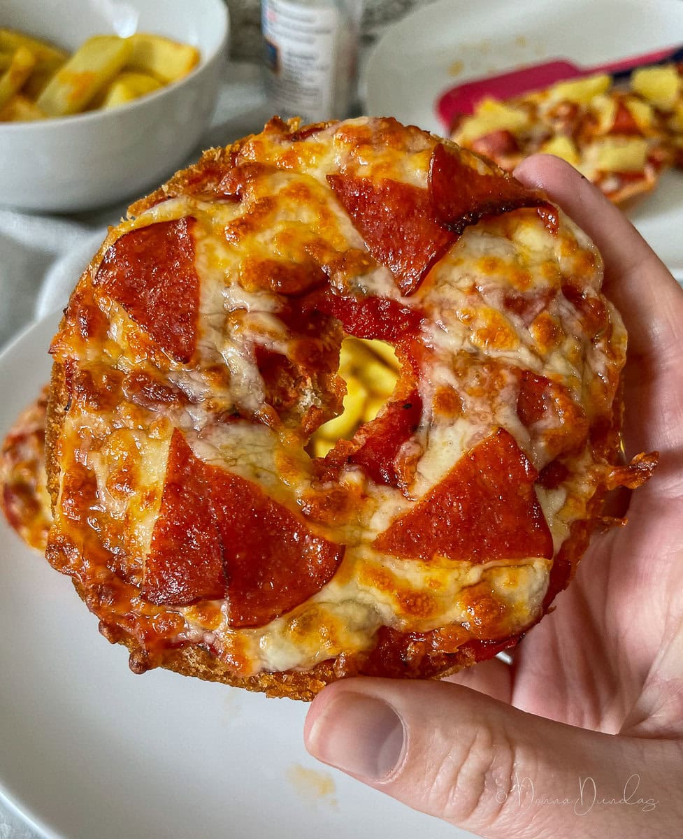 close up of air fryer pizza bagel with pepperoni.