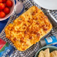 Hotdog mac and cheese in glass cooking dish.