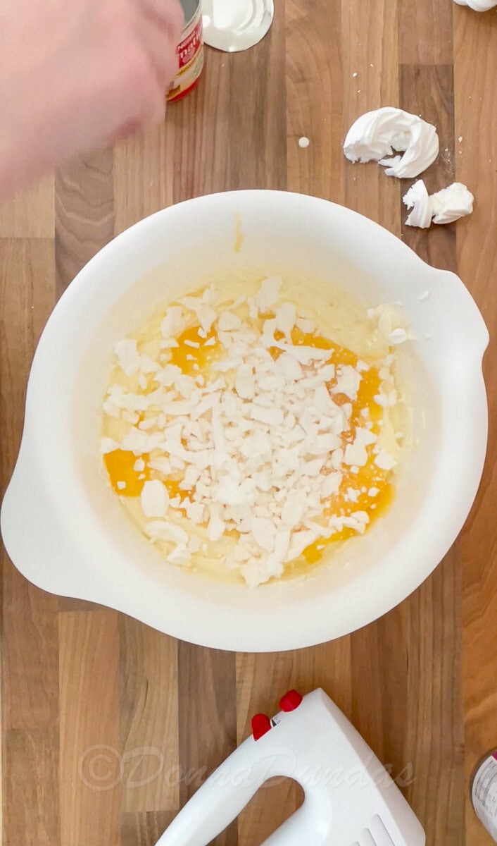 ice cream mixture with lemon curd and meringue in mixing bowl.