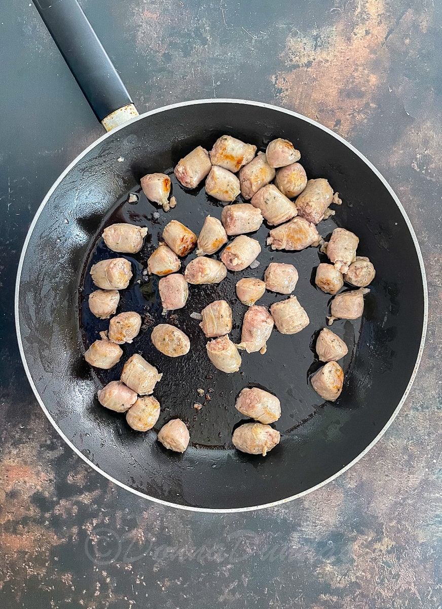 sausage chunks in frying pan.