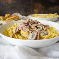 served bowl of ham and mushroom tagliatelle.