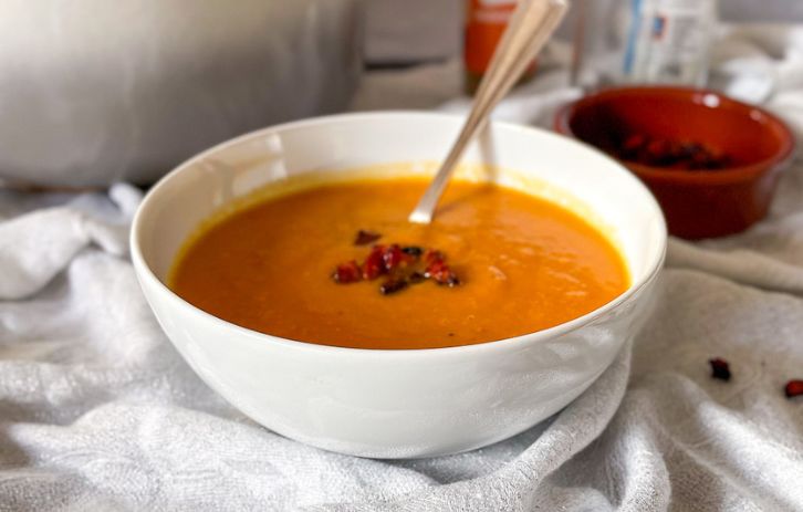 Sweet Potato and Chorizo soup in bowl with cripsy chorizo pieces on top.