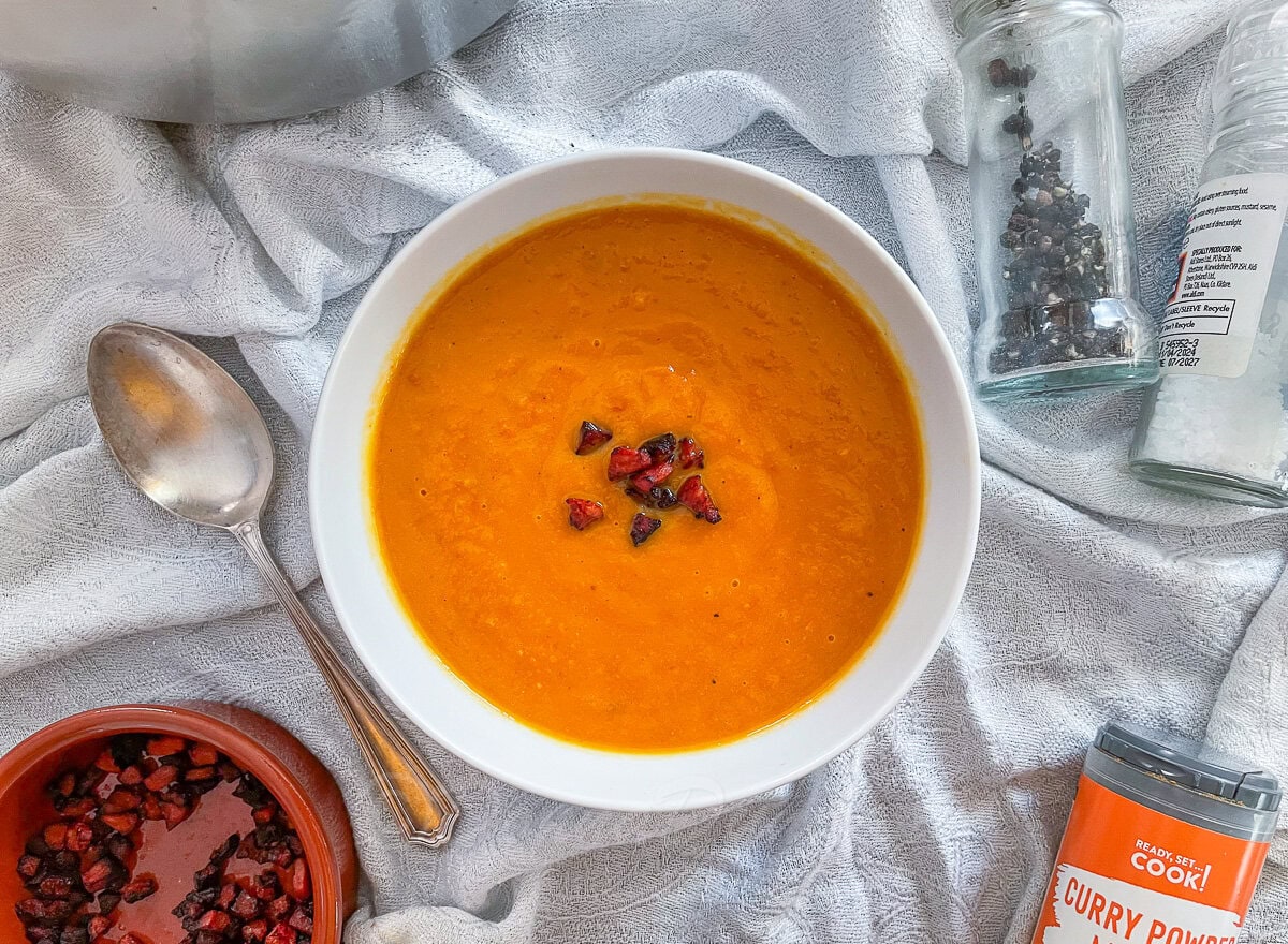 Sweet Potato and Chorizo soup in bowl with cripsy chorizo pieces on top.