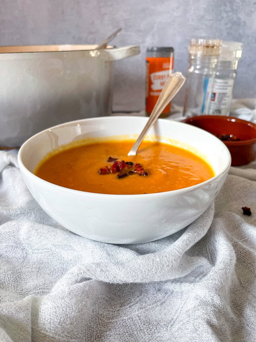 Sweet Potato and Chorizo soup in bowl with cripsy chorizo pieces on top.