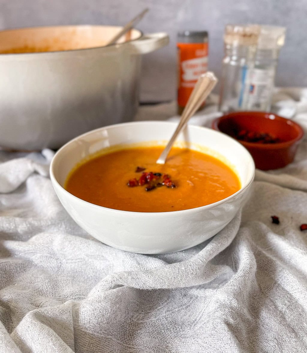 Sweet Potato and Chorizo soup in bowl with cripsy chorizo pieces on top.