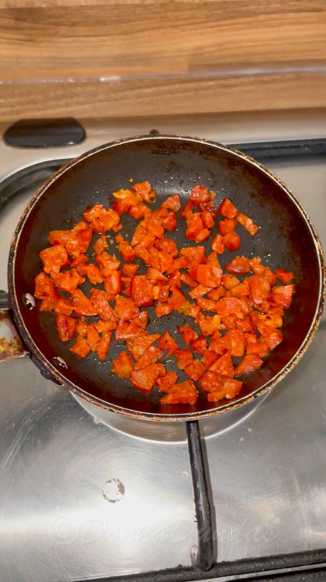 diced chorizo frying in small pan.