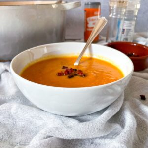 Sweet Potato and Chorizo soup in bowl with cripsy chorizo pieces on top.