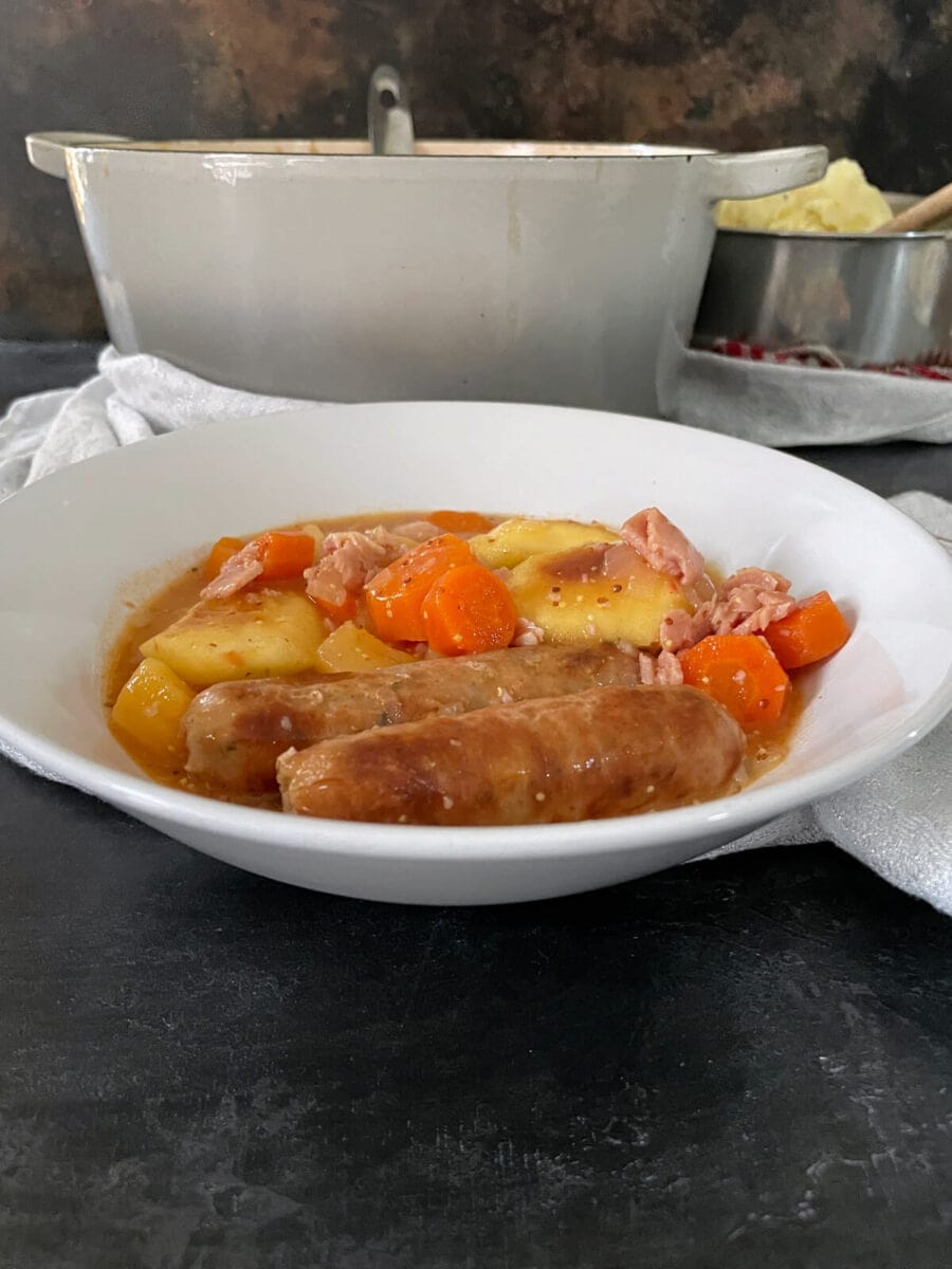 served portion of sausage casserole with apples and cider.