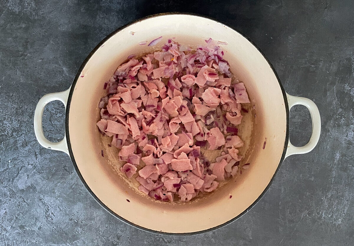 bacon and onions frying in dish.