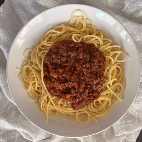 served portion of spaghetti and red lentil bolognese.