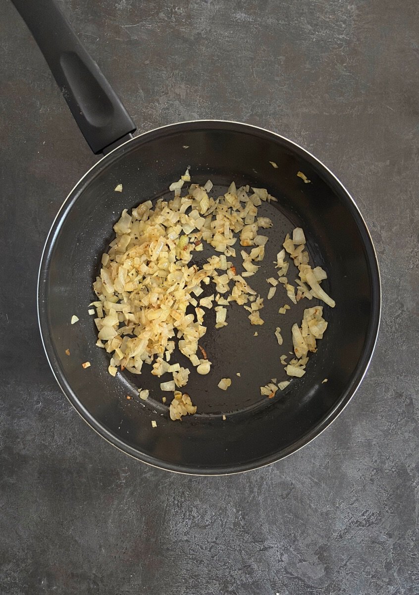 onions frying in pan with salt and pepper.